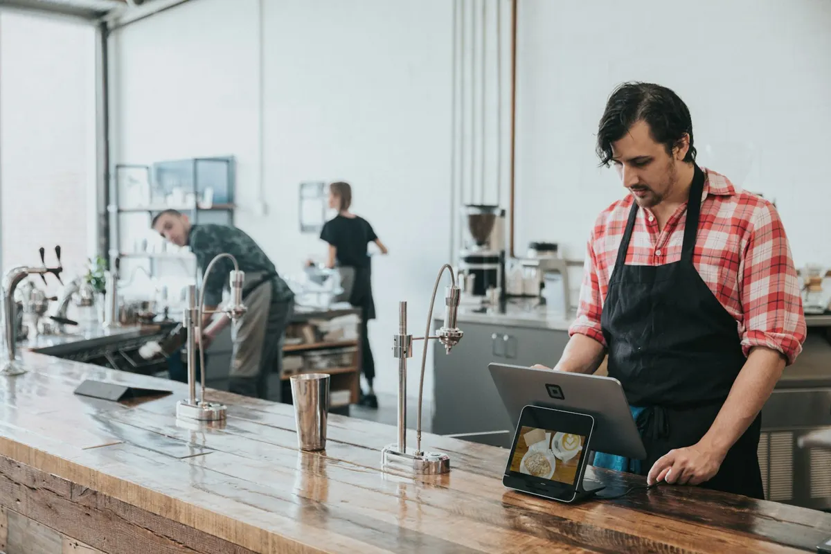 Barista lucrând la tejgheaua unei cafenele