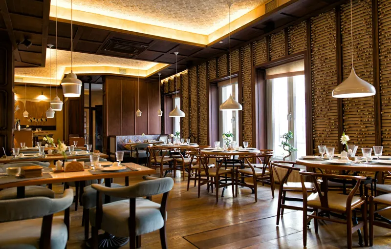 Restaurant cu mese de lemn și lumini calde