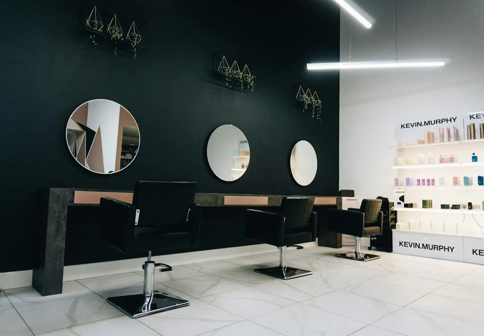 Interiorul salonului, cu oglinzi rotunde și scaune negre